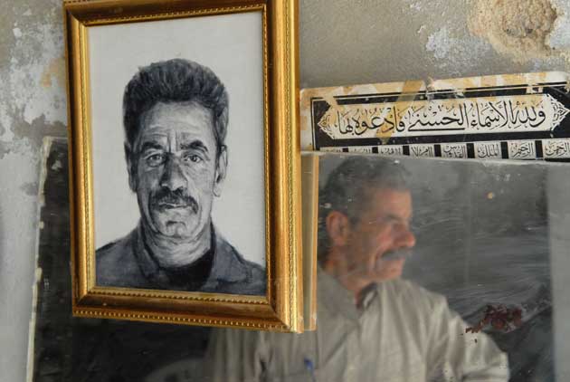Stallholder reflected in the mirror next to his portrait