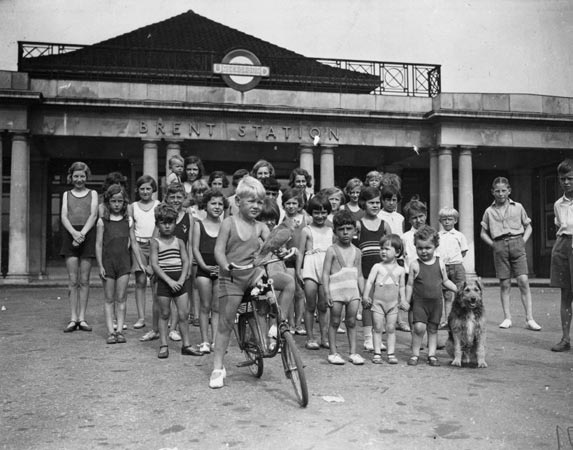 A parrot and a crowd of children outside Brent underground station in August 1932