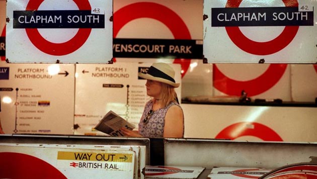 In 1999, a woman browses at a Lloyds auction of old underground signs