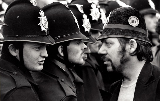A face off between an NUM picket and lines of police, who have removed their numbers from their coat shoulders, in what became known as the Battle of Orgreave