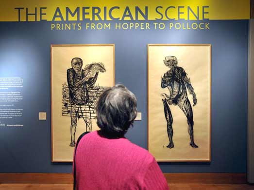  A visitor looking at Leonard Baskin's works, the 'Hydrogen Man' (R) and 'The Man of Peace' (L)