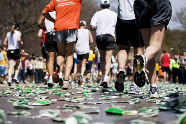 Runners quench their thirst at a water station during the 112th Boston Marathon