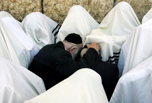 Jewish priests or Cohanim cover their heads and faces with the their Talit or prayer shawl as they take part in a blessing for the Jewish people, at the Wailing Wall