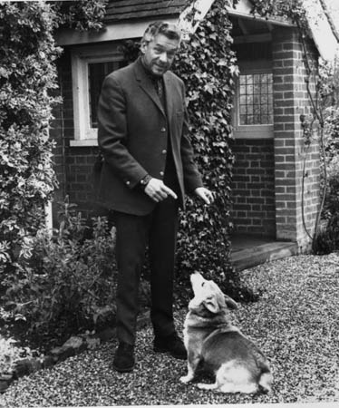 Paul Scofield poses with his dog in the yard of then home in Balcombe, England