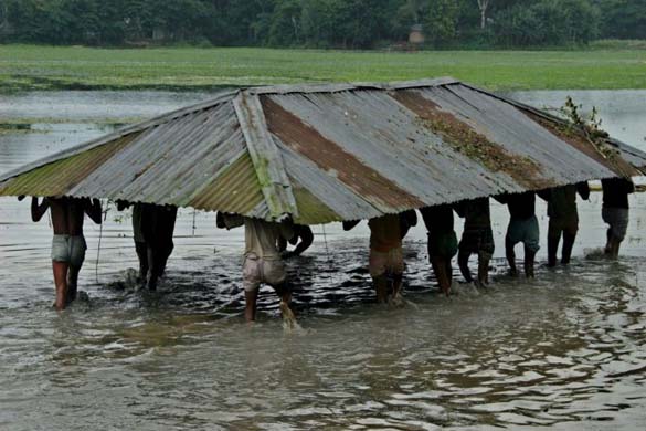 Family members move their house to a through floodwater