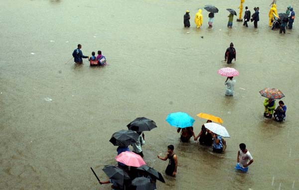 People wade through a flooded road