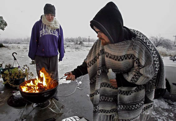 Man cooks for his wife while attempting to keep warm during a power cut