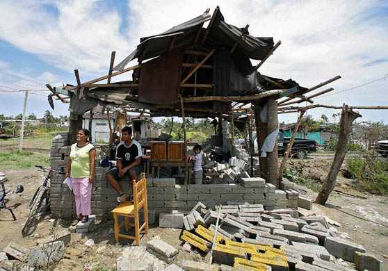 A family at their house which was destroyed by Hurricane Dean