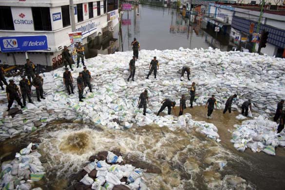 Aerial view of Mexican army soldiers building a dam from sand bags