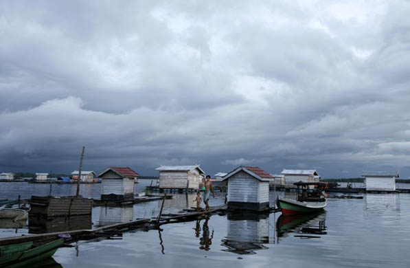 A fishermen walks with his children in Sumbulu village
