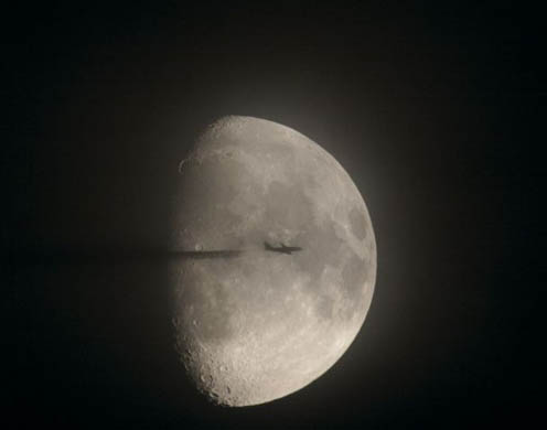 Plane passing in front of the moon