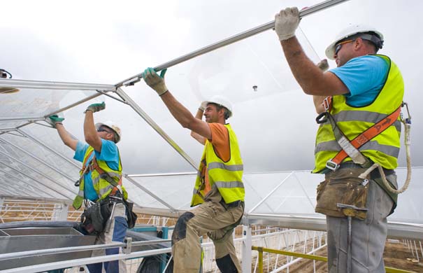 Workers install a glass panel