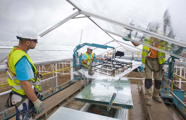 Workers install glass panels