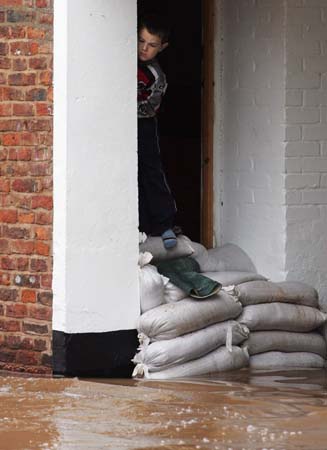 A boy looks at flood water in Upton-upon-Severn