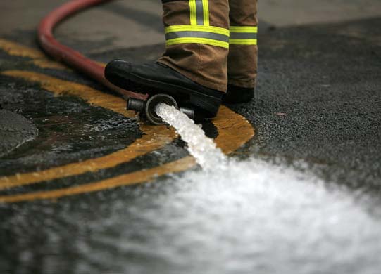 Firefighter pumping out floodwater