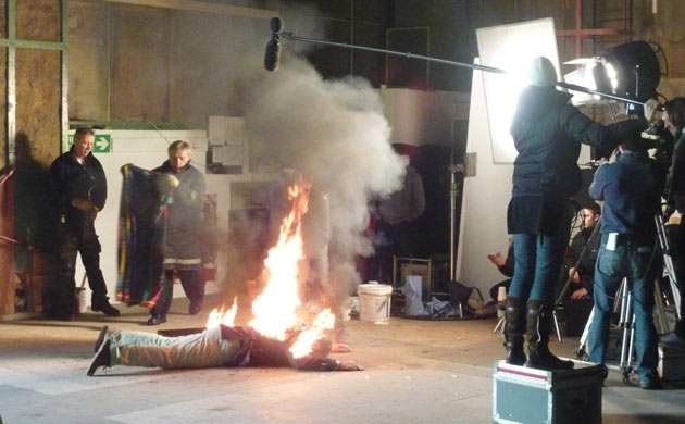Actor lying on the floor and on fire