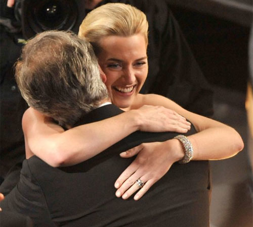 Kate Winslet hugs her husband, director Sam Mendes, after winning the best actress Oscar for her role in The Reader