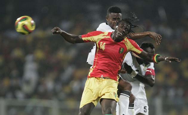 Gyan, Menash of Ghana challenge for ball with Soumah of Guinea