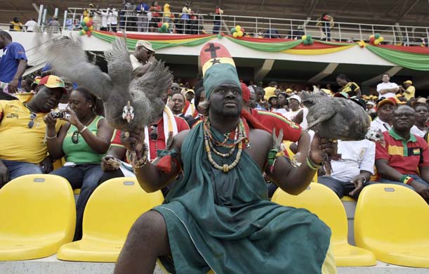 A fan from Ghana holding a guinea fowl in the stadium