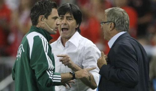 The head coaches Joachim Loew, center, and Josef Hickersberger, right, argue with the match's fourth official Damir Skomina. Boach coaches were sent to the stands in the first half.
