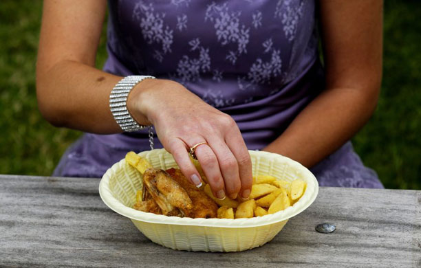A lady has chicken and chips in a basket