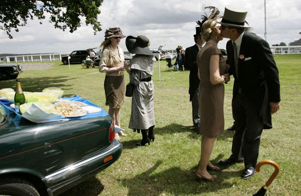 Friends greet each other in the car park during a picnic by their car