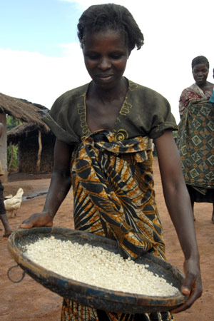 A woman shakes maize in a traditional basket