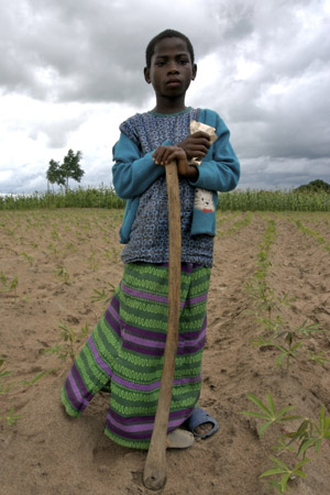 Mercy standing in a cassava field