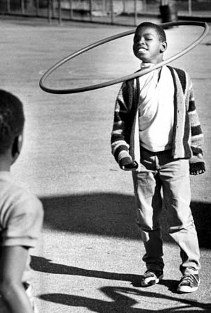 A boy with a hula hoop in the 1960's