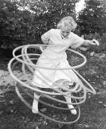 A girl twirls eight hula hoops simultaneously