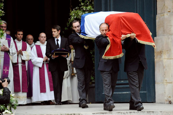 The coffin of Yves Saint Laurent, covered by the French flag, is carried out of the church after the funeral mass in Paris