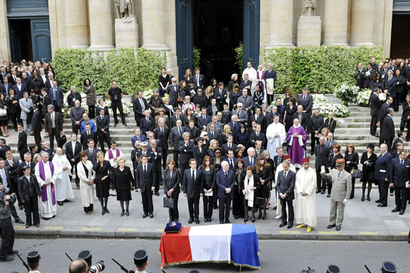 Mourners gather outside the church in front of the coffin