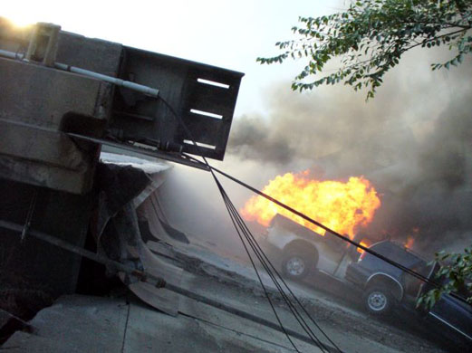 Vehicles burn in the wreckage of the bridge