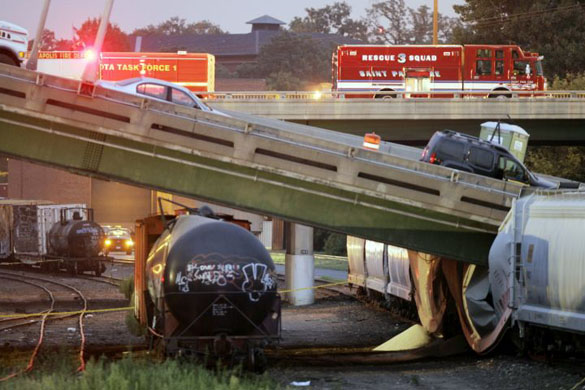 A section of the bridge rests on freight cars after collapsing