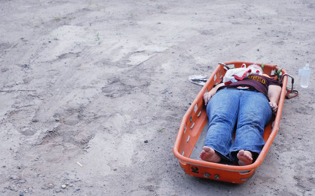 A victim waits for emergency help after being caught in the collapse of the bridge