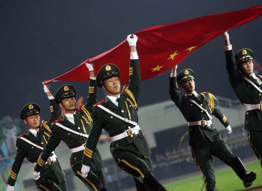 Soldiers carry a Chinese national flag
