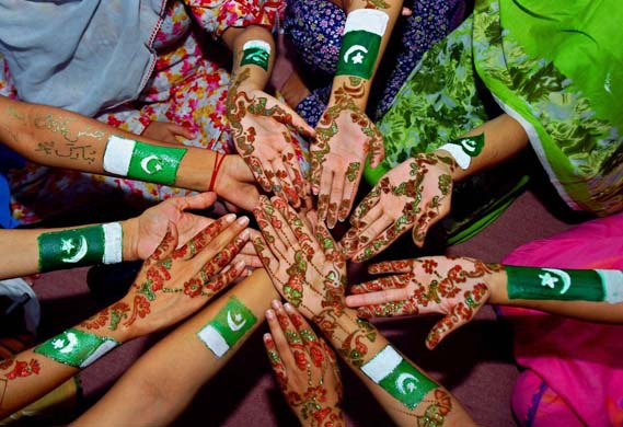 Students show their hands painted with traditional heena and national flags