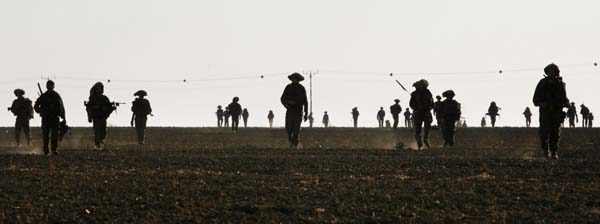 Infantry soldiers walk out of Gaza