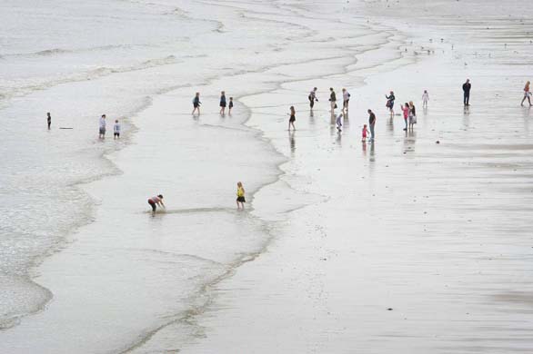Holidaymakers ignore the grey skies to take a dip in the sea