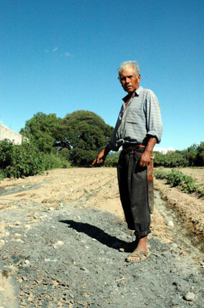 Farmer Mariano Barragan points at the blue-grey crust