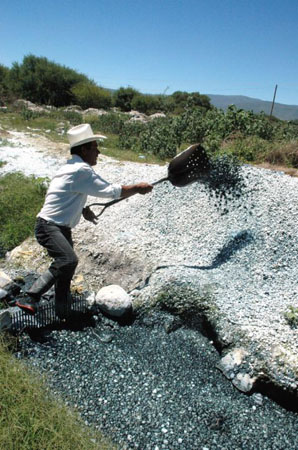 Worker Belisario Dorantes clears away pumice stone