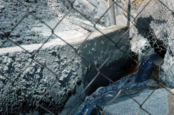 The untreated waste flows down a canal towards an irrigation channel used by local farmers