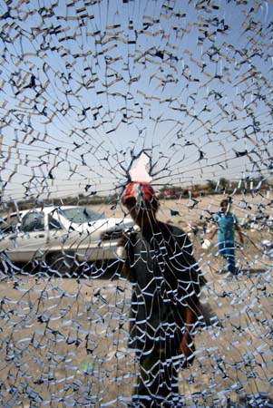 A man is seen through the shattered window of a bus