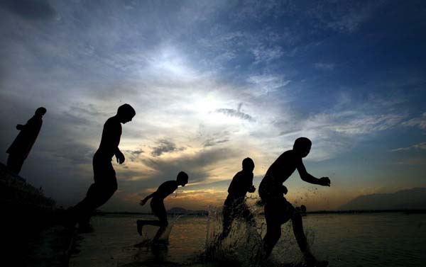Boys jump into Dal lake to beat the heat
