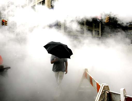 A man walks through steam rising from a construction site