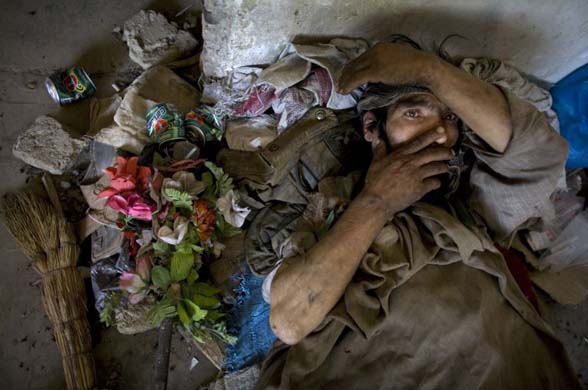 Akbar, a heroin addict , rests on the floor of an abandoned building