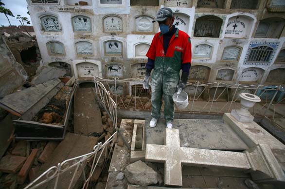A worker looks at a coffin that was uncovered during 