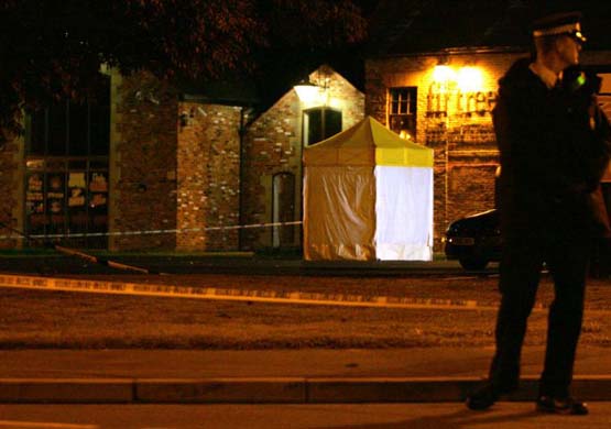 A police forensic tent stands at the scene of a shooting