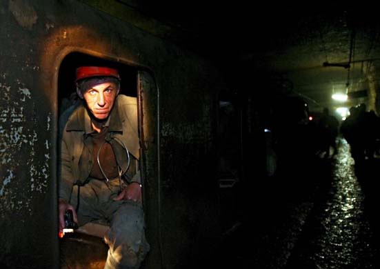 A miner looks out of a carriage in Leningradskaya slate mine