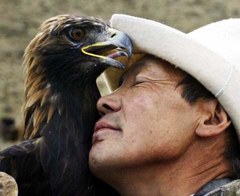 A hunter holds a golden eagle
